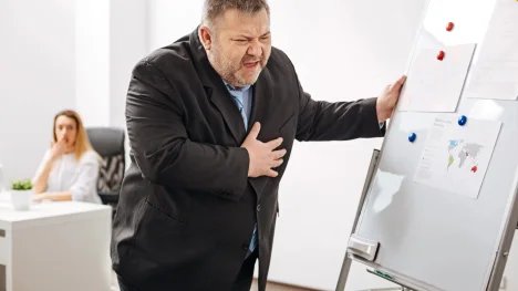 Obézní muž držící se na hrudi