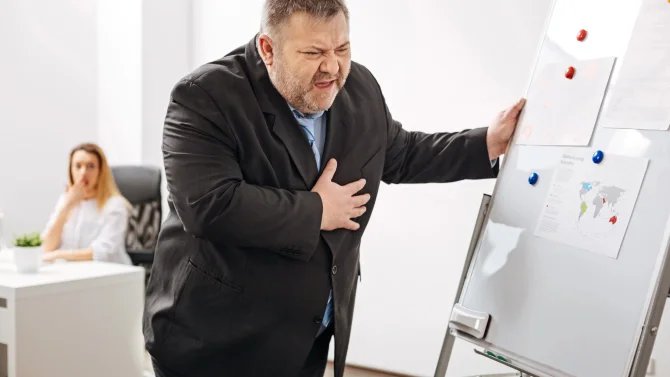 Obézní muž držící se na hrudi